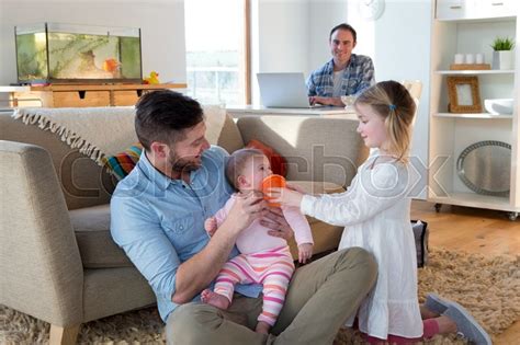 same sex male couple at home with their two daughters one