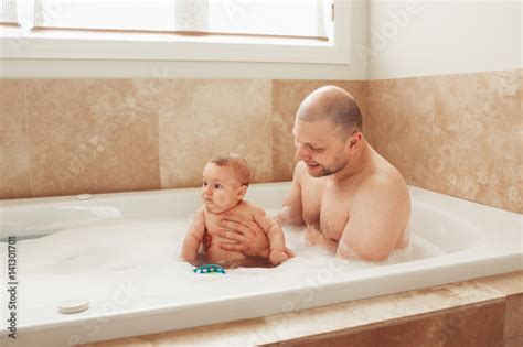 portrait of white caucasian middle age father taking bath together with