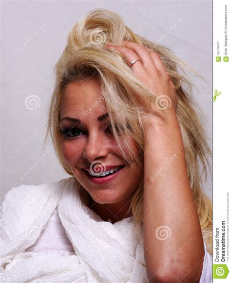 a smiling blond haired woman is looking into the camera stock image