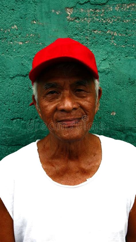 A Matured Filipino Man Stands Against A Green Wall Editorial Image