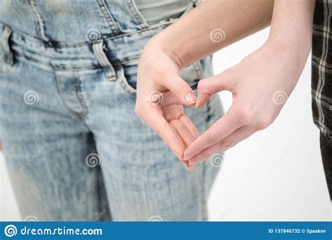 two girls in jeans hold hands close up white background