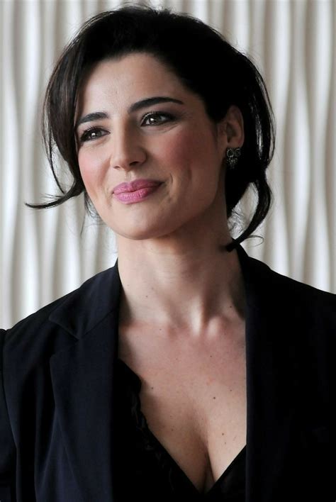 A Woman Wearing A Black Jacket And Smiling At The Camera