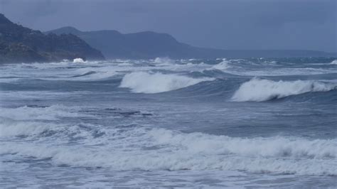 Stormy Ocean Sea With Crashing Waves On Rocks And Cyclone Hurricane