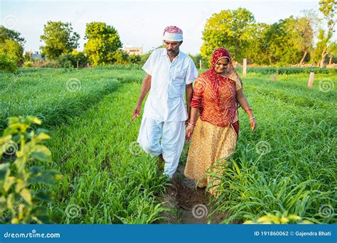 indian farmer couple walking    agriculture green field
