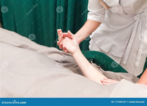 Doctor Cosmetologist Massages The Hands Of His Patient Client Of A
