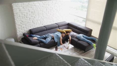 Drunk Friends Sleeping On Sofa In Messy Room Stock Footage Sbv
