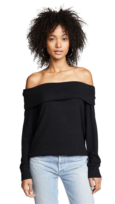 A Woman Wearing A Black Off The Shoulder Top