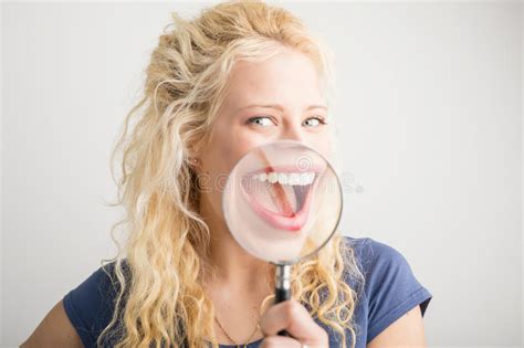 woman with magnifying glass showing teeth stock image