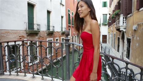 happy beautiful woman in red summer dress walking over