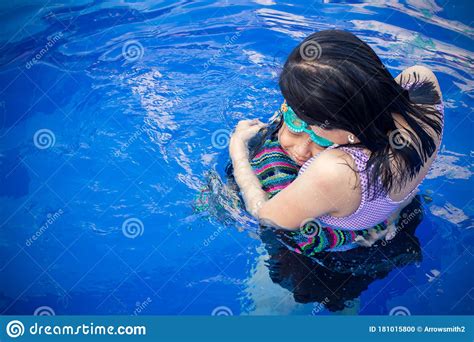 asian daughter hugging with her mother at the swimming