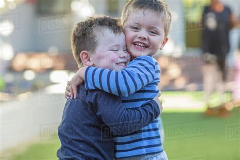 young boys outdoors hugging stock photo dissolve