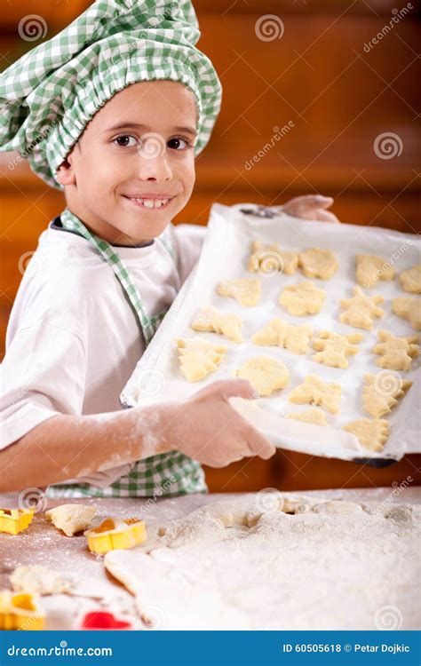 de jonge jongensleider toont voorbereide koekjes voor baksel stock foto image  koekjes