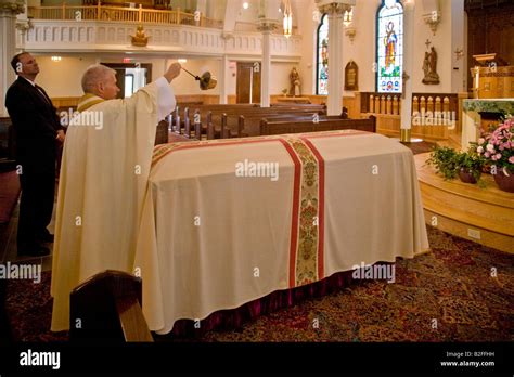 priest waves  senser   casket   catholic funeral mass