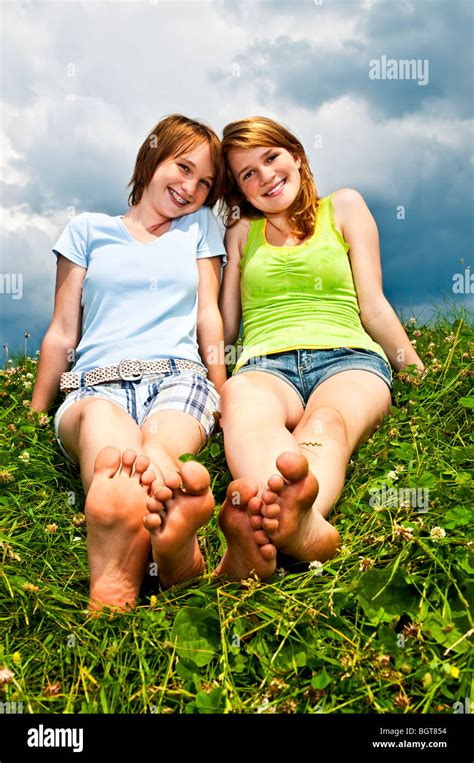 zwei junge teenager mädchen freunde sitzt barfuß auf sommerwiese