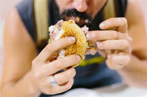 close up portrait of bearded man eating burger portrait