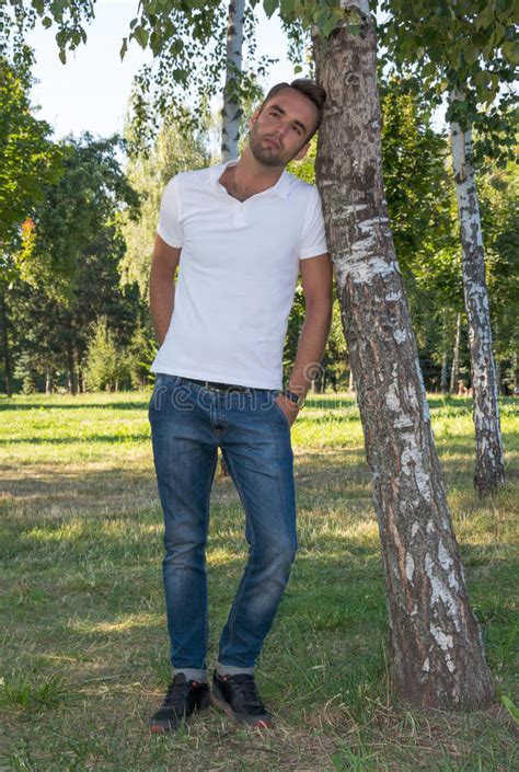 young man standing  tree  park  summer stock image image  relaxation foliage