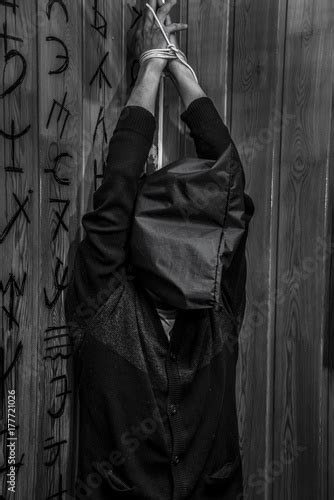 A Man With His Hands Tied Hanging From The Ceiling Buy This Stock