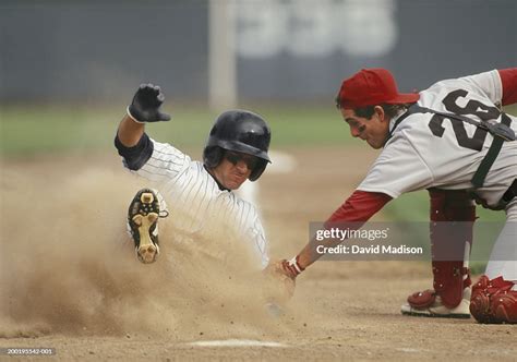 baseball player sliding  home plate  tagged  catcher high