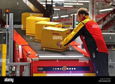 schkeuditz germany  oct   dhl employee puts  parcel   carrier belt