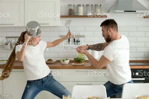 Funny Couple Having Fun Fighting With Kitchen Utensils Cooking T Stock