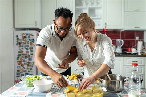 couple cooking together in kitchen by mihajlo ckovric couple multiethnic