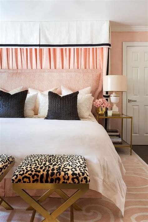 cheetah print x stools sit on a pink damask rug in front of a bed