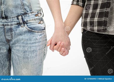 Two Girls In Jeans Hold Hands Close Up White Background Homosexual