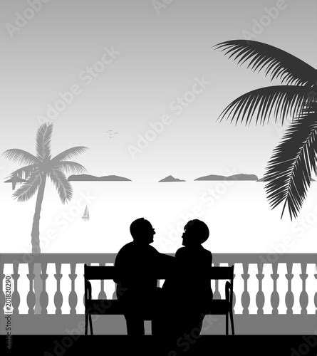 lovely retired elderly couple sitting on bench on the beach one in the