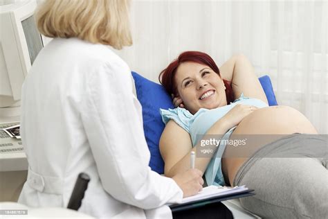 pregnant woman answering questions to female doctor gynecologist high
