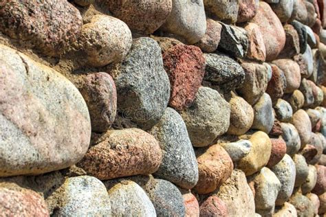 de natuursteenmuur van ronde steen voor en achterachtergrond vertroebelde met bokeheffect stock