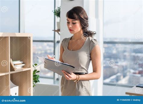 portrait   concentrated female office assistant reading  writing