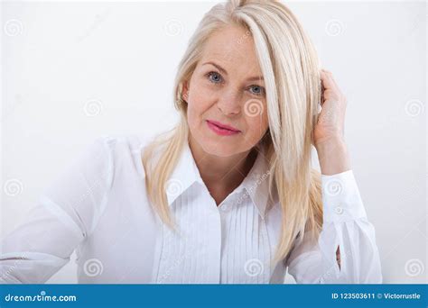 lovely middle aged blond woman   beaming smile sitting  office