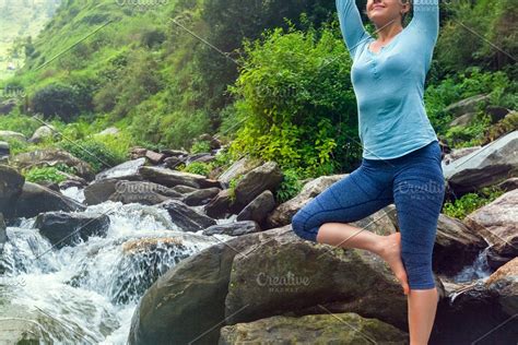 woman  yoga asana vrikshasana tree pose  waterfall outdoors