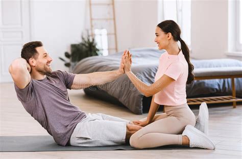 sporty couple training together doing abs exercise at home stock image
