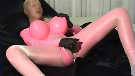 Girl In Pink Latex Catsuit With Big Boobs And Shiny Encasement