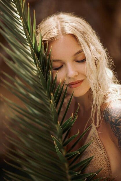 Premium Photo Sexy Beach Blonde Girl In Knitted Bikini With Palm Leaf