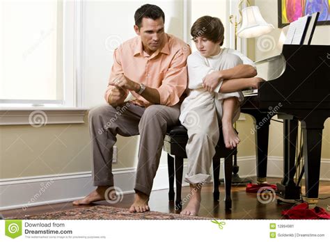 Serious Father Talking To Teenage Son At Home Stock Image