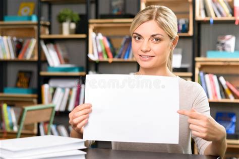 woman sits desk pointing paper stock   royalty  stock