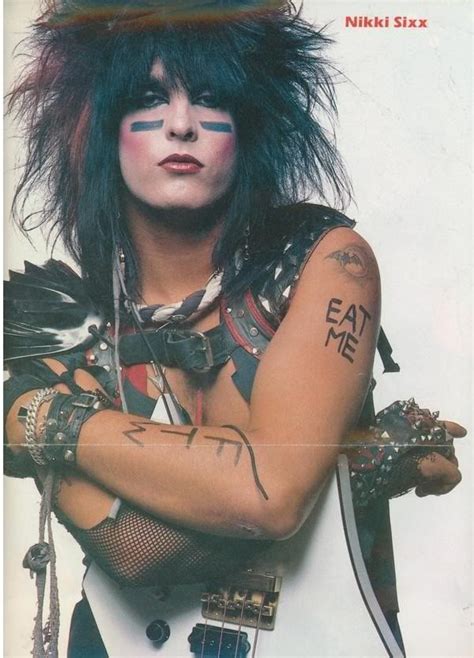 a woman with tattoos and piercings on her arm posing for a magazine