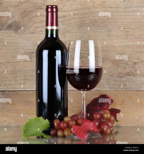 rotwein  weinflasche vor einem hintergrund aus holz stock photo