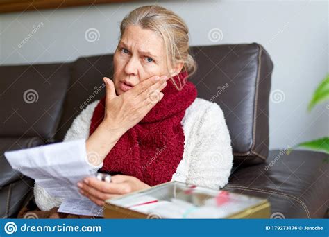senior woman sitting at a table in her living room reading the