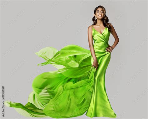 fashion model dancing in green silk dress with flying chiffon fabric