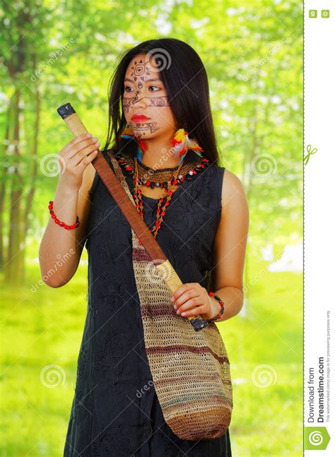 exotische vrouw uit de amazone met gezichtsverf en zwarte kleding het natuurlijke zak hangen