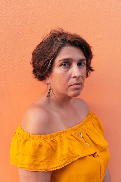 Premium Photo Mature Latin Woman With Colorful Orange Background