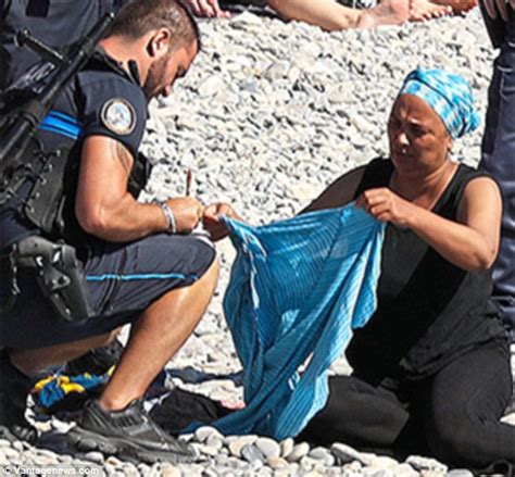 get em off armed police order muslim woman to remove her burkini on packed nice beach as