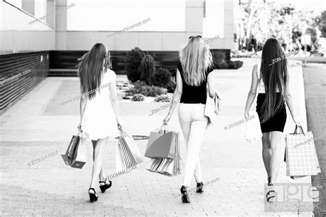Girls Holding Shopping Bags And Walk Around The Shops Smiling