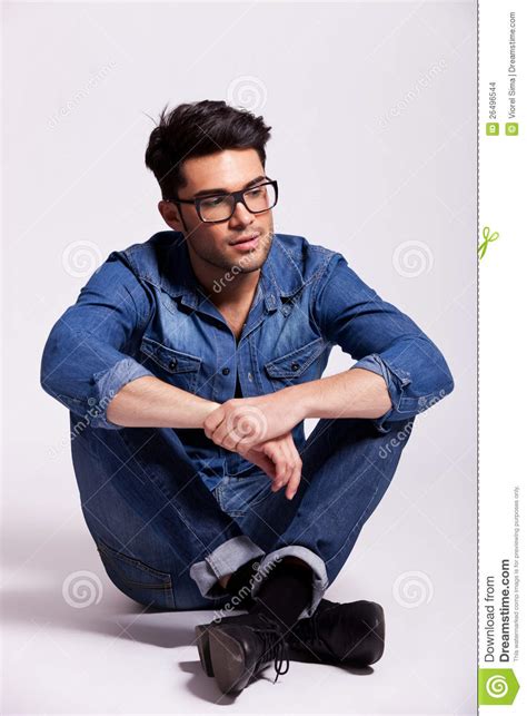 Man Wearing Jeans Shirt And Glasses Sitting Stock Images
