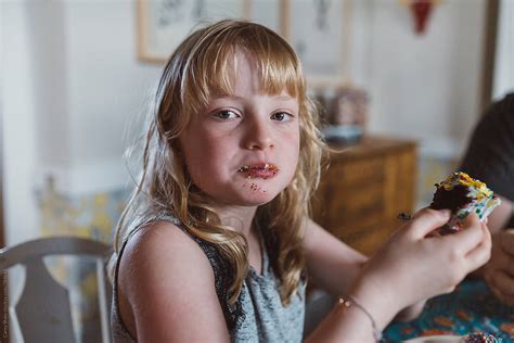 Young Girl Eating Cupcake With Messy Face By Stocksy Contributor