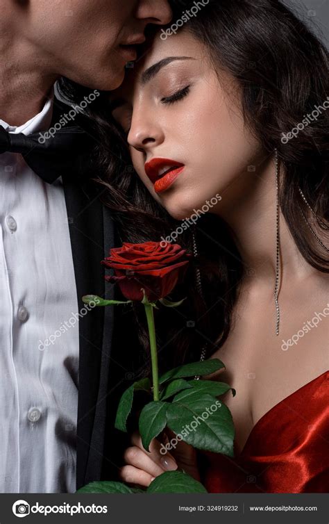 cropped view romantic couple hugging holding red rose flower — stock