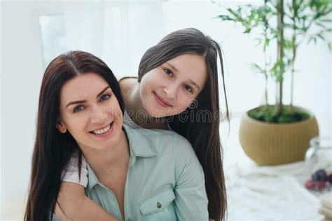 beautiful mother and her cute daughter smiling and posing at home